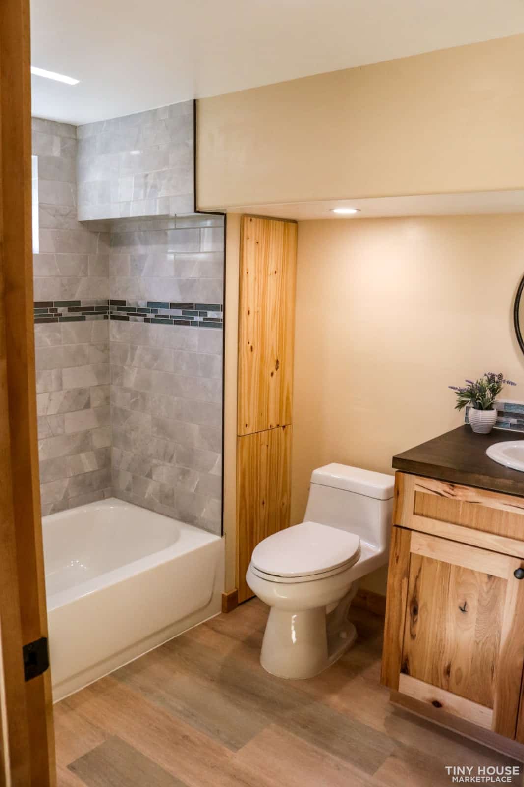 Full bathroom with residential soaking tub and marble-look tile shower surround