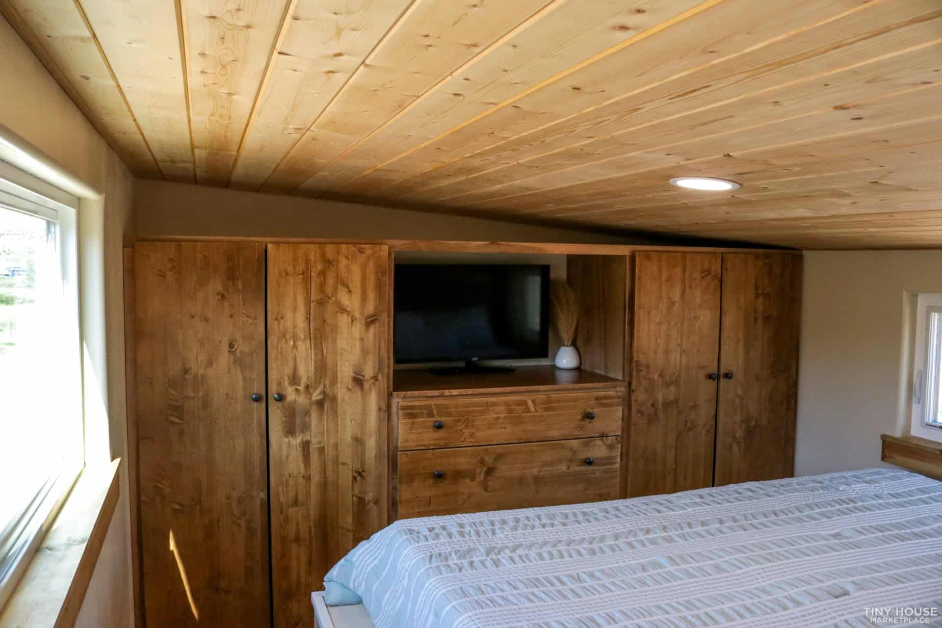 Upstairs bedroom with built-in wardrobes, dresser and mounted TV