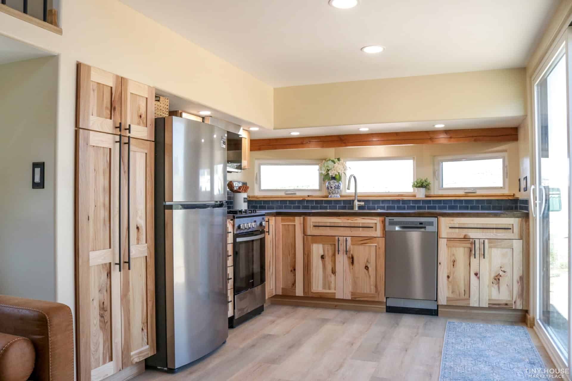 Felicity tiny house kitchen with full-size refrigerator and tall pantry cabinet