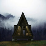 A-Frame tiny house with modern interior design nestled in a forest setting.