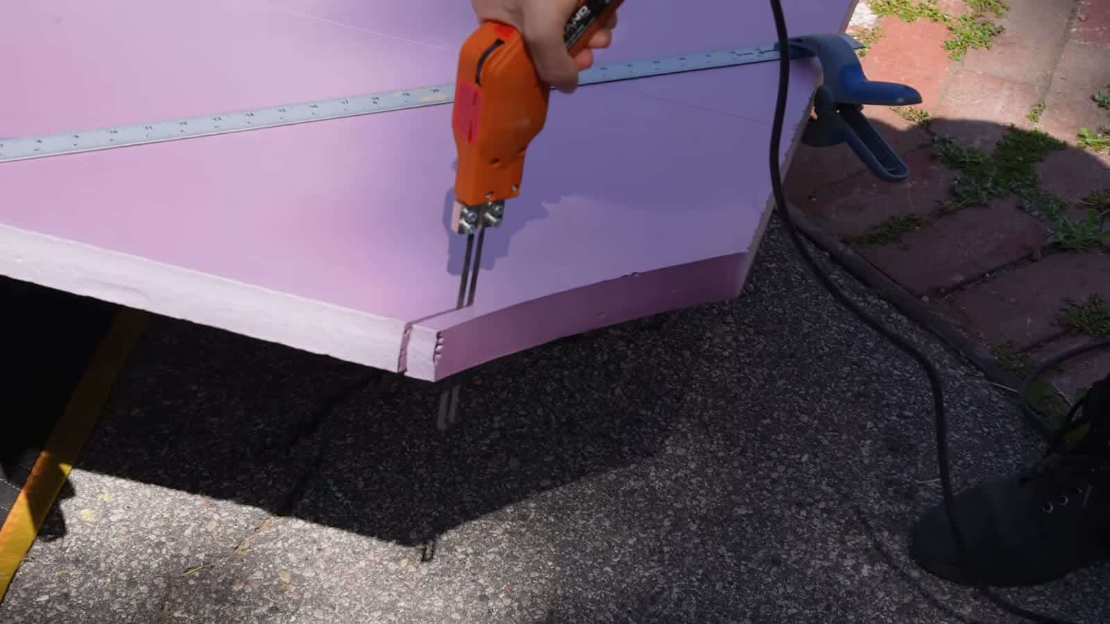 Cutting a pink rigid foam insulation panel with a foam-cutting blade