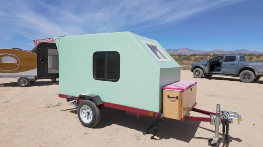 Mint green foam teardrop camper with striped tongue box parked in the desert