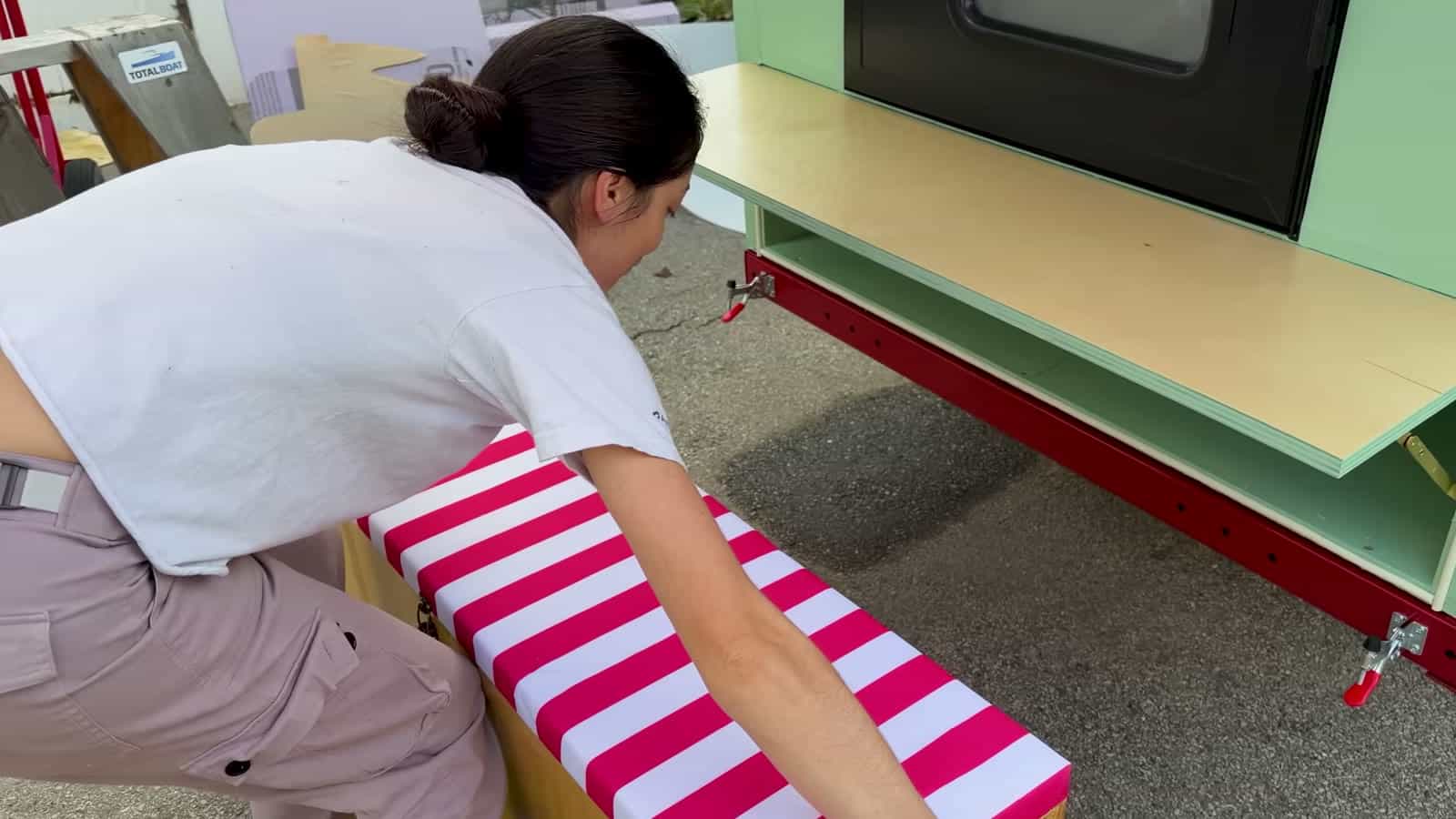 Striped upholstered tongue box seat below the fold-down camp counter