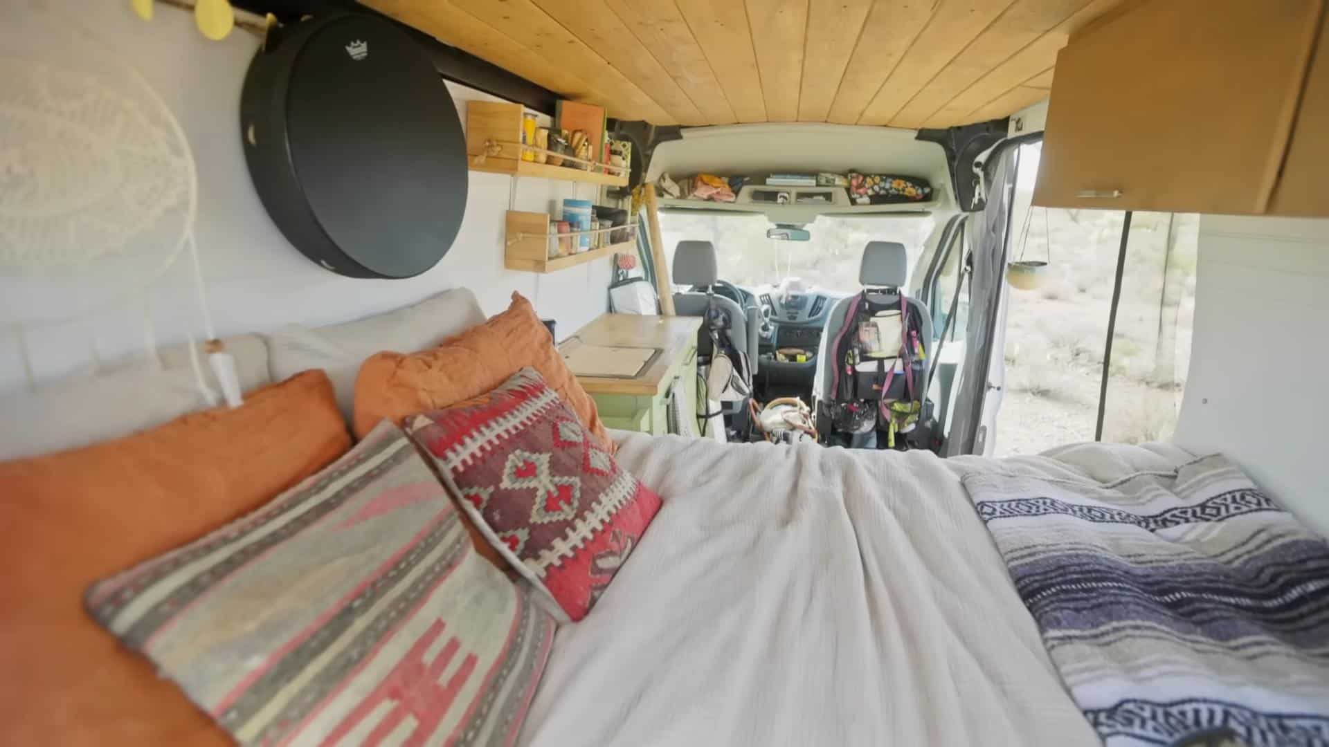 Interior view of a tiny van converted into a cozy living space with reclaimed materials and function.