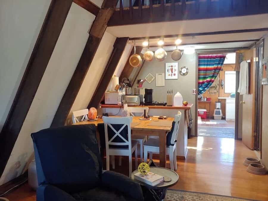 Interior view of a cozy A-frame tiny house with a dining area and kitchen in Fort Davis, Texas.