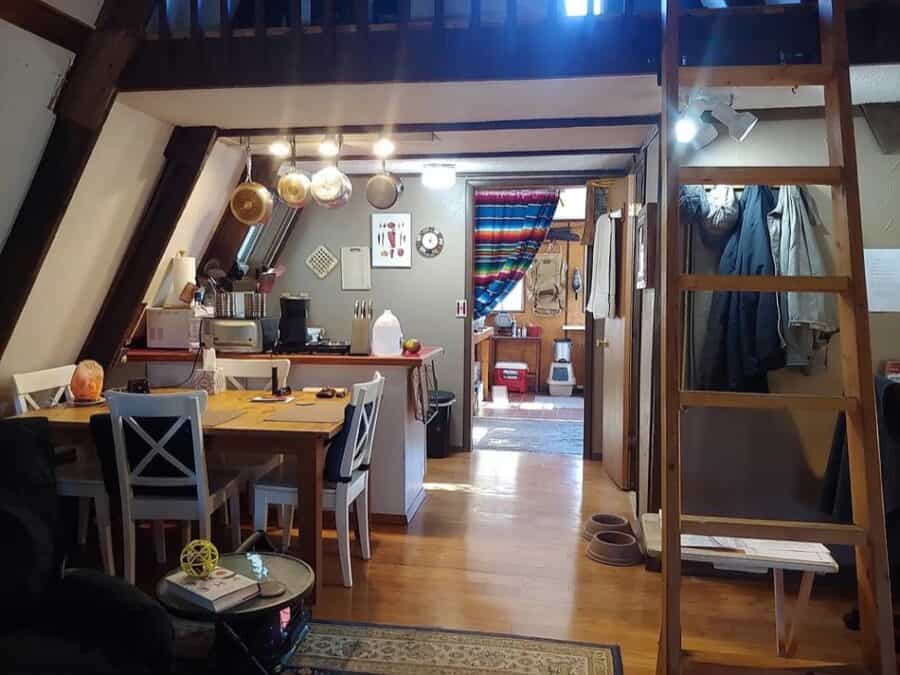 Compact tiny house kitchen and dining area in a small A-frame cabin.