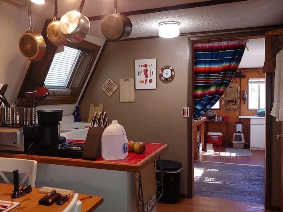 Interior view of a cozy tiny A-frame cabin with kitchen and dining area in Texas.