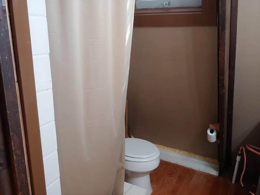 Compact bathroom in a tiny house with a toilet and minimal decor.
