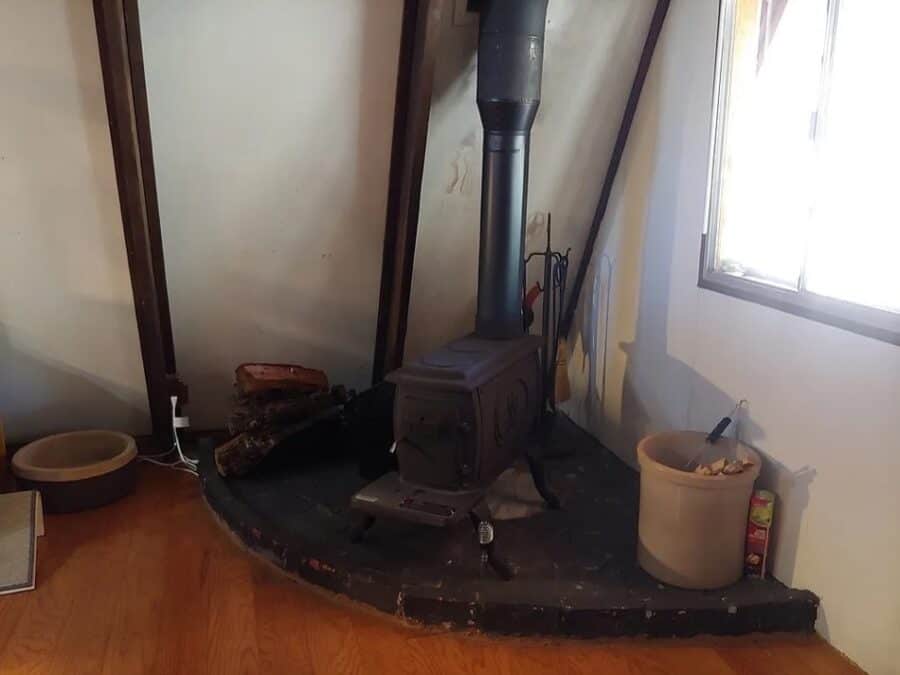 Cozy interior featuring a wood stove in a small cabin space.