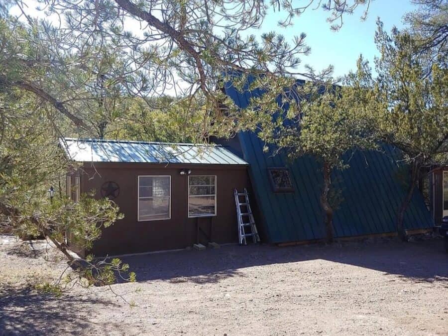 A-Frame tiny house nestled among trees in Fort Davis, Texas, showcasing innovative small space livin.