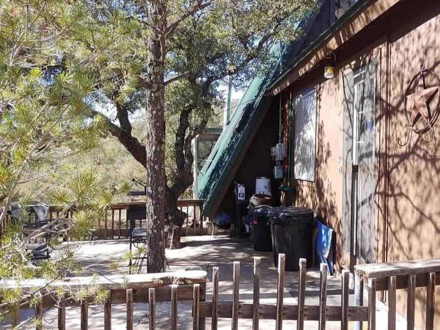 Cozy A-frame tiny house with outdoor deck and trees in Fort Davis, Texas.