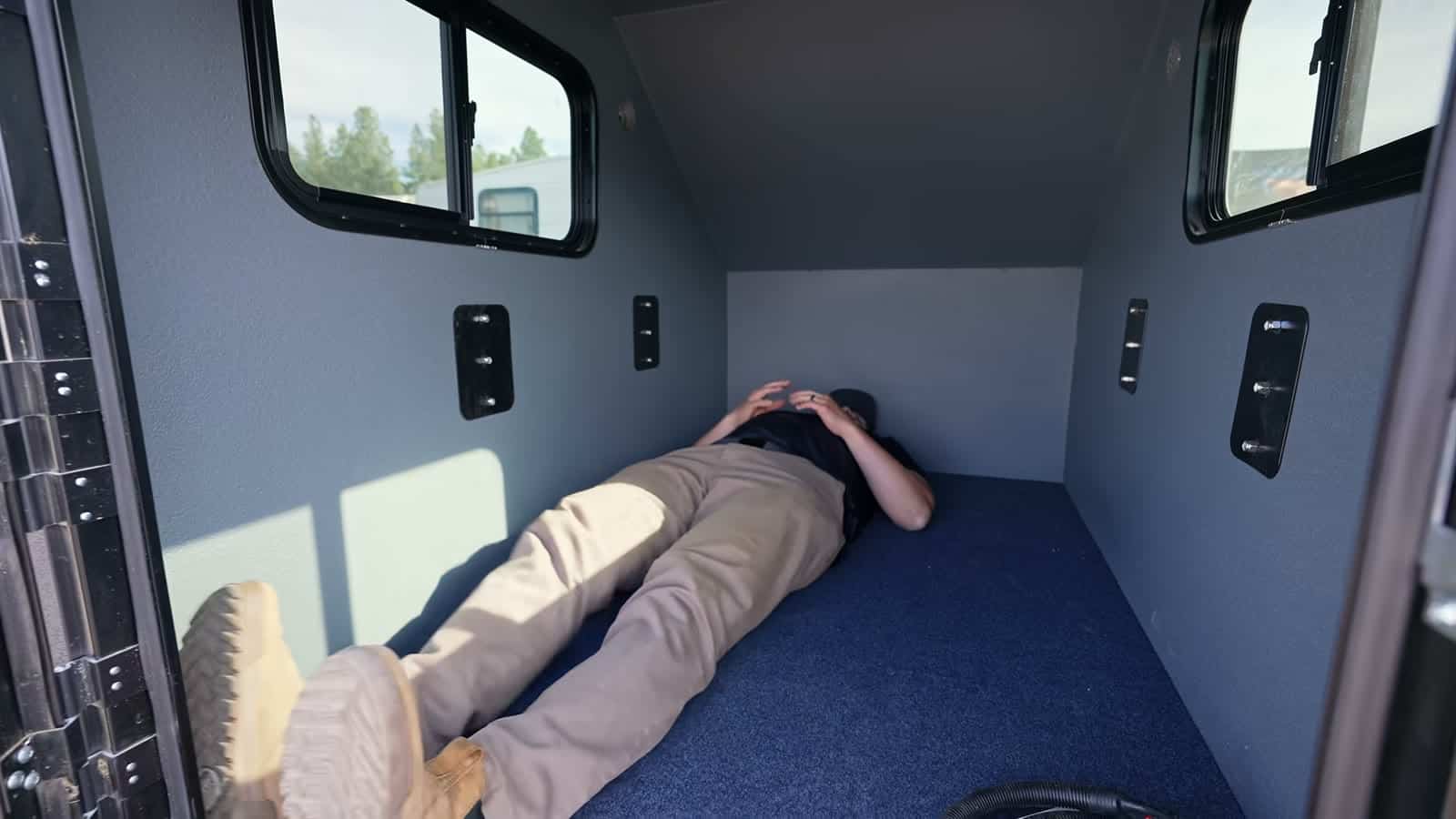 Man lying down inside a Freedom Camper to show sleeping length