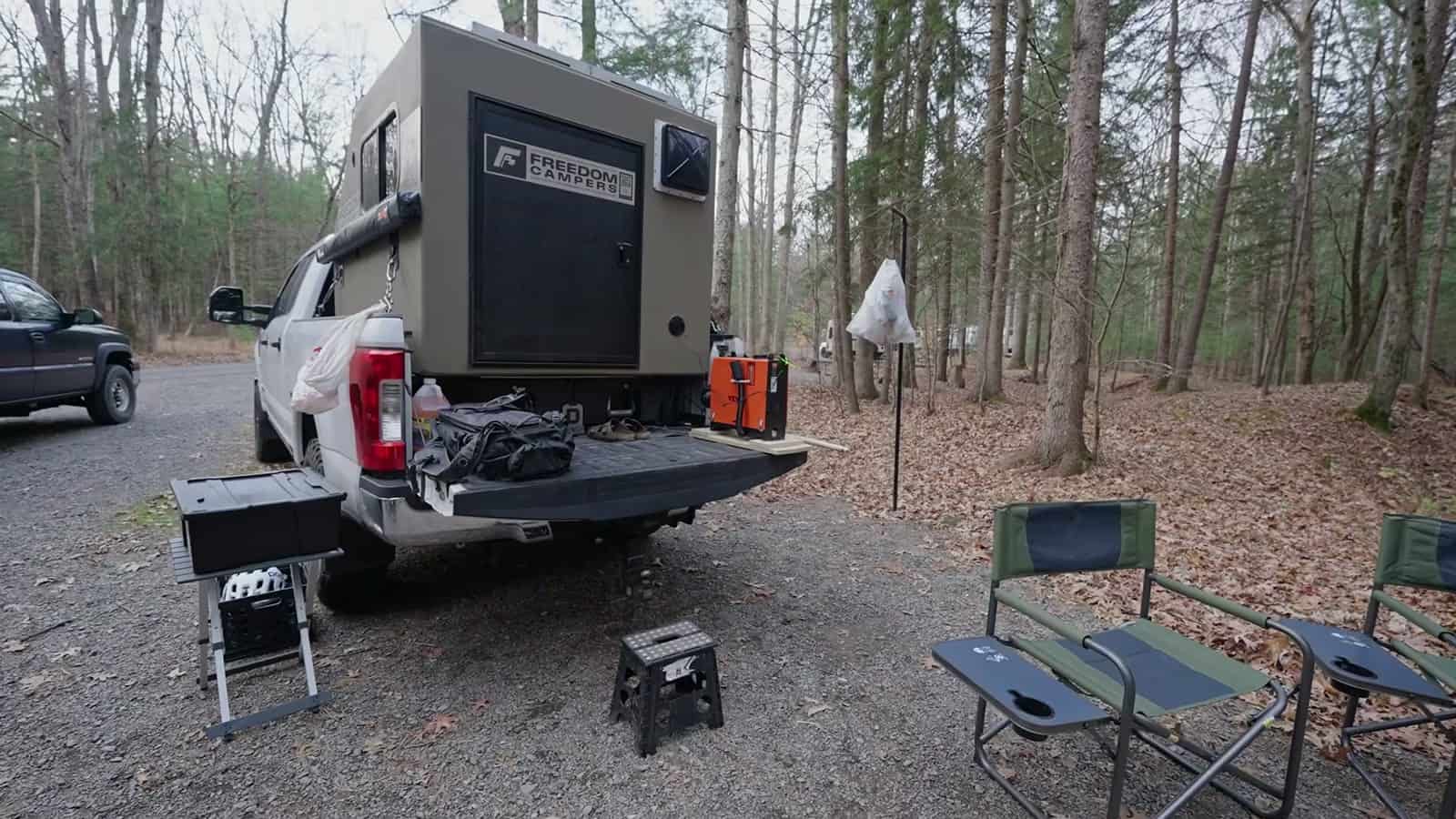 Freedom Camper in a pickup at a wooded campsite