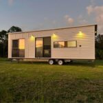 Compact tiny home with modern design and outdoor lighting.