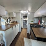 Skoolie kitchen with modern appliances and cozy design.