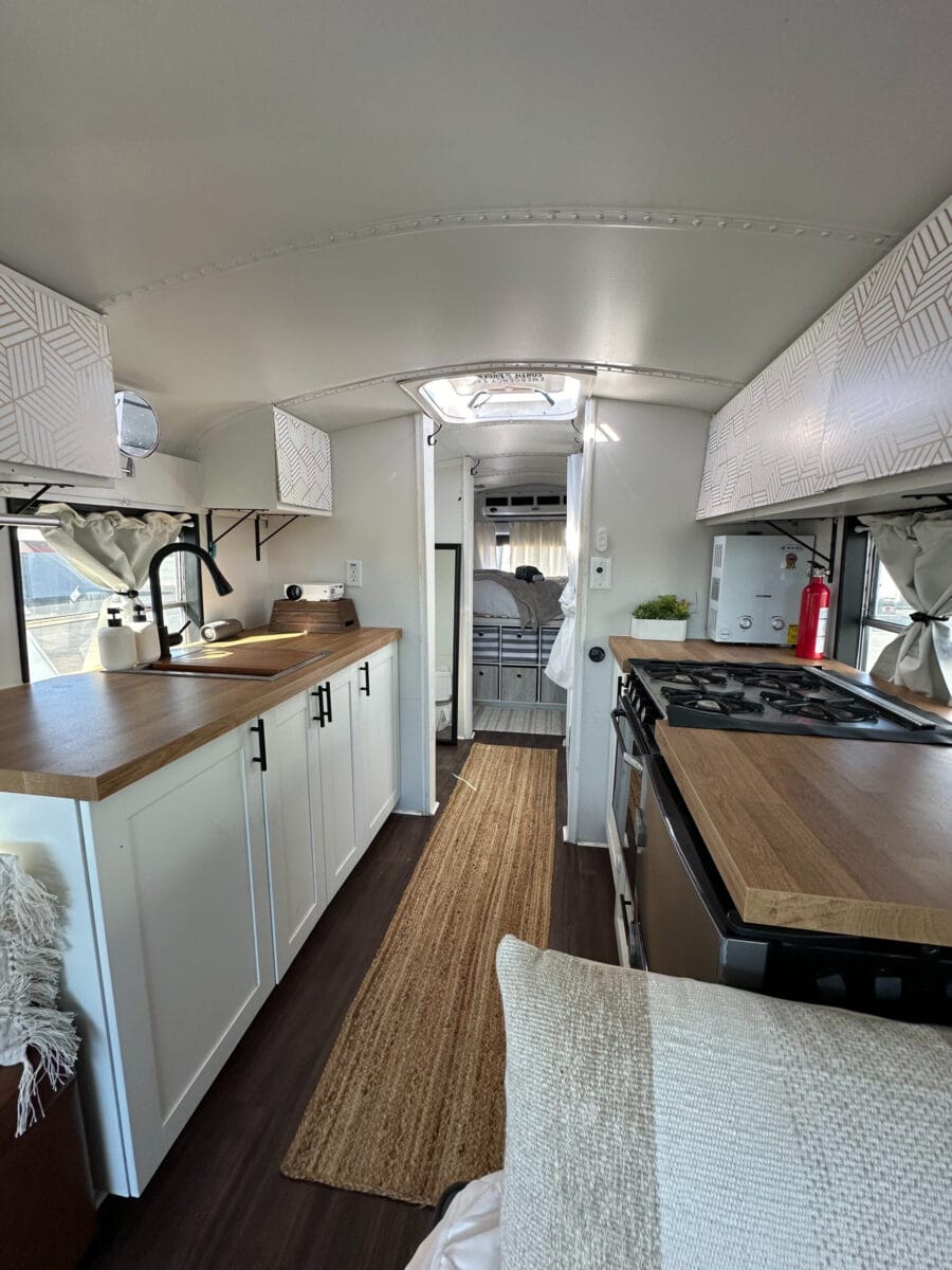 Skoolie kitchen with modern appliances and cozy design.
