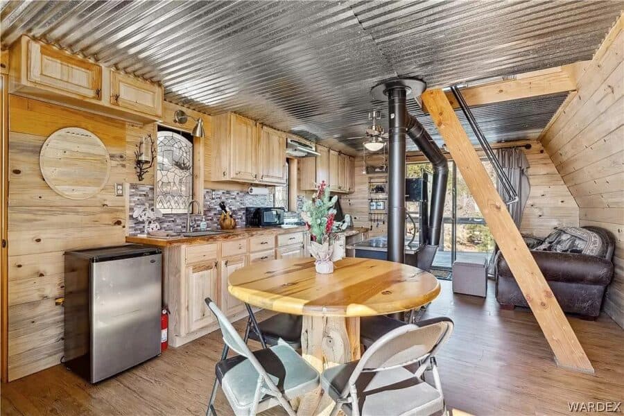 Charming tiny cabin interior featuring wooden accents and mountain scenery outside.