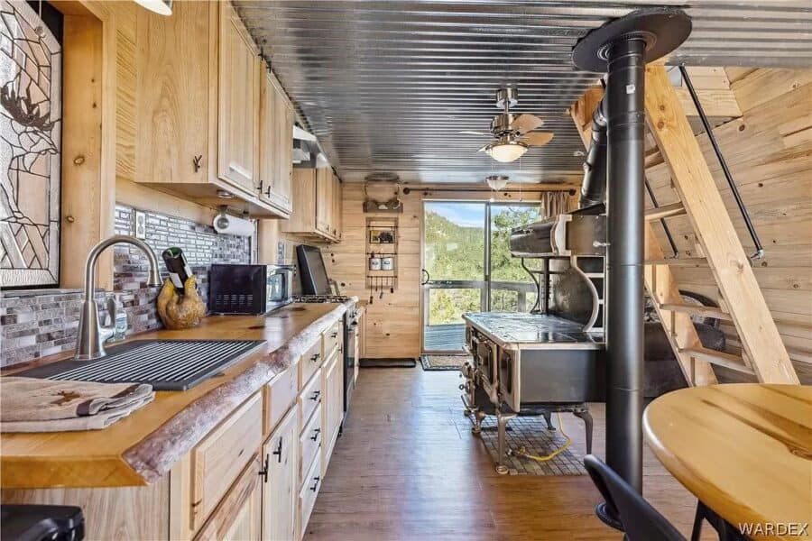 Charming tiny cabin kitchen featuring wood accents, modern appliances, and scenic mountain views in.