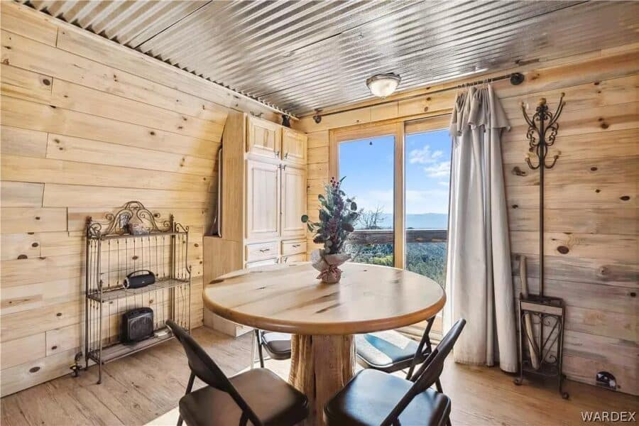 Charming mountain-view cabin interior with wooden walls and large window. Perfect for small space li.