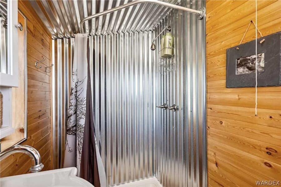 Bathroom with metal shower wall in a tiny house interior.