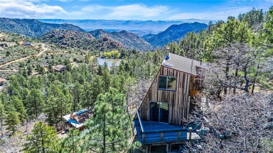 Tiny house nestled among pine trees with mountain backdrop in Arizona.