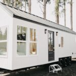 Modern tiny house with arched windows and a first-floor bedroom, perfect for small space living.