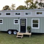 Charming tiny house featuring a first-floor bedroom, modern design, and efficient space utilization.