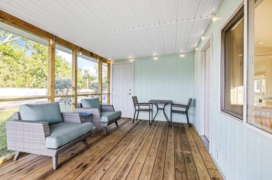 Bright outdoor porch with seating and scenic views.
