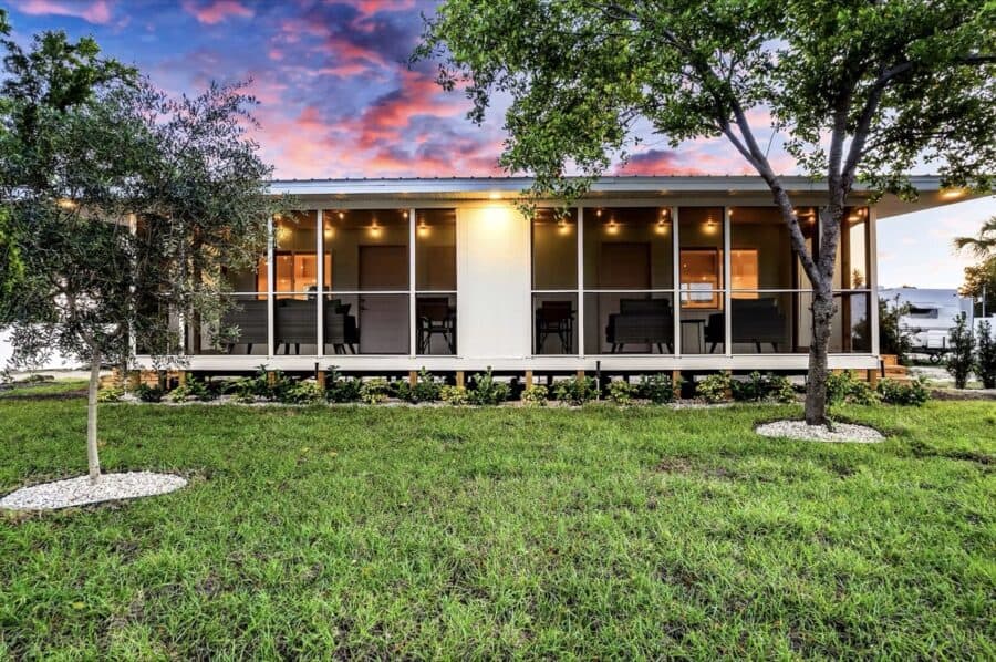 Grove Duplex screened porch with outdoor seating area surrounded by landscaping