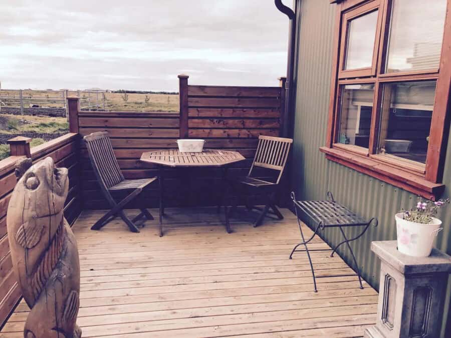 Cozy Icelandic guesthouse outdoor deck near Selfoss with wooden furniture and scenic views.
