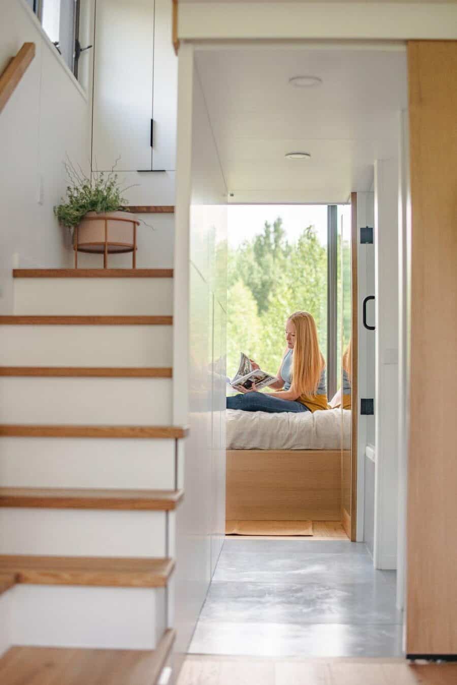 Interior view of a tiny house with a cozy nook and natural light, showcasing efficient small space d.