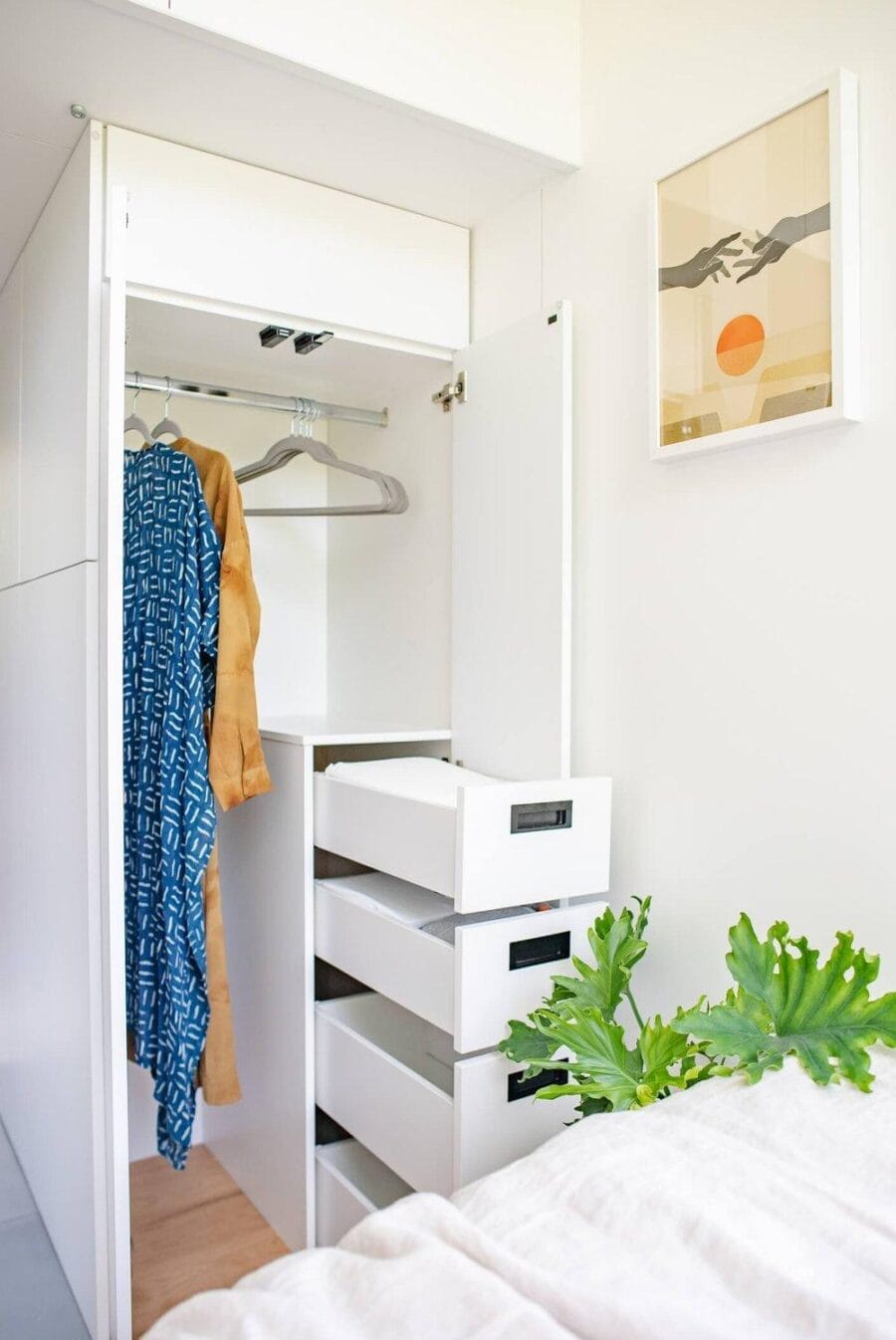 Compact closet with hanging space and drawers in tiny house.