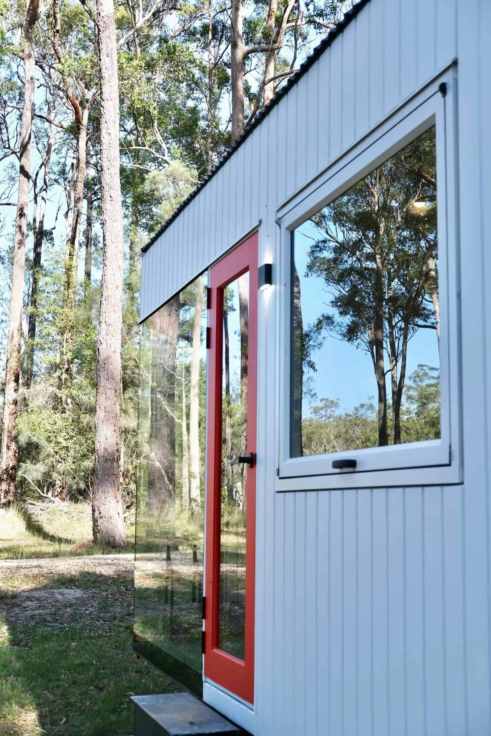 Side exterior view of the Eire tiny house showing steel cladding and large windows