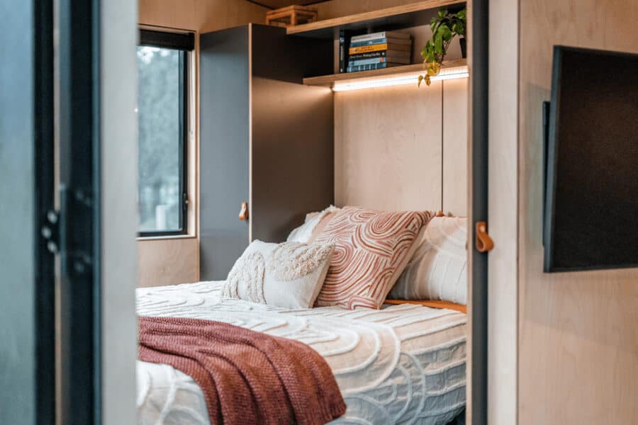 Cozy tiny house bedroom with built-in storage and modern decor.