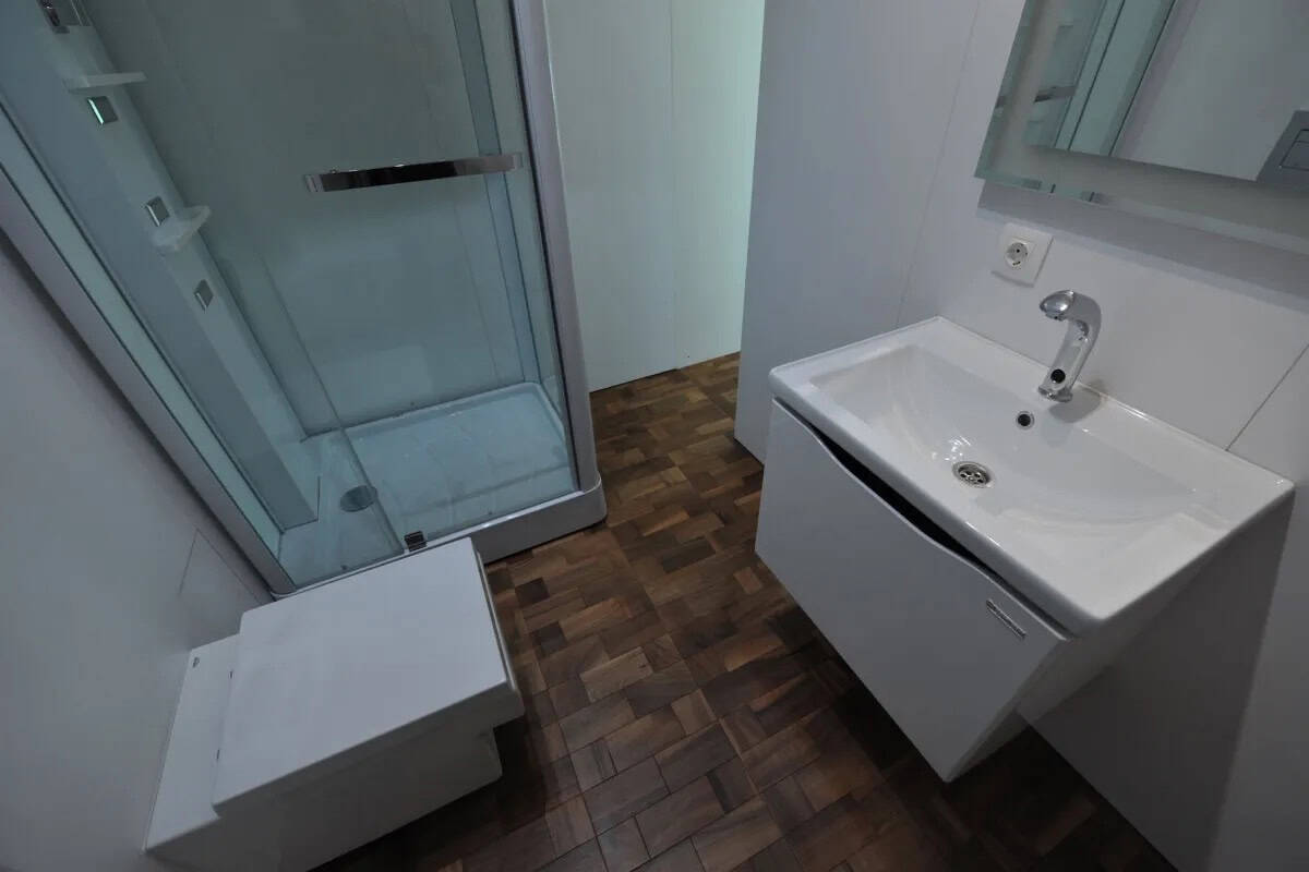 Bathroom with compact shower and modern sink in tiny house.