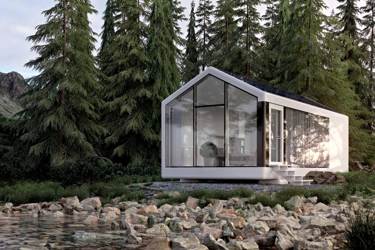 Modern tiny house with large glass windows surrounded by trees and rocky landscape.