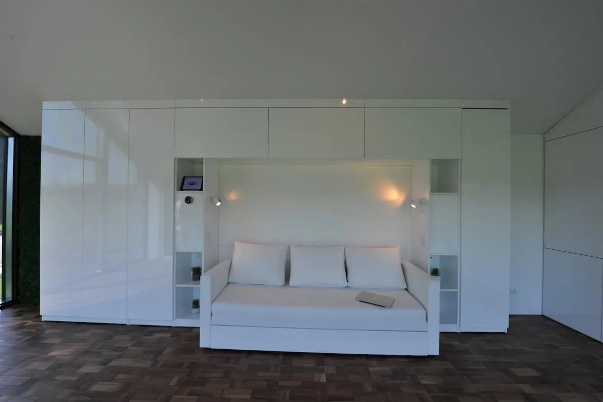 Modern minimalist tiny house interior with white walls and built-in storage.