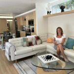 Woman relaxing on a modern tiny house sofa with colorful pillows in Tampa Bay.