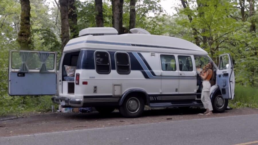 Retro van parked in forest, perfect for tiny house living on wheels.