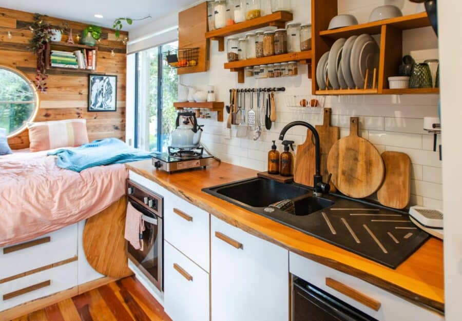 Compact tiny house kitchen with wooden accents and efficient design.