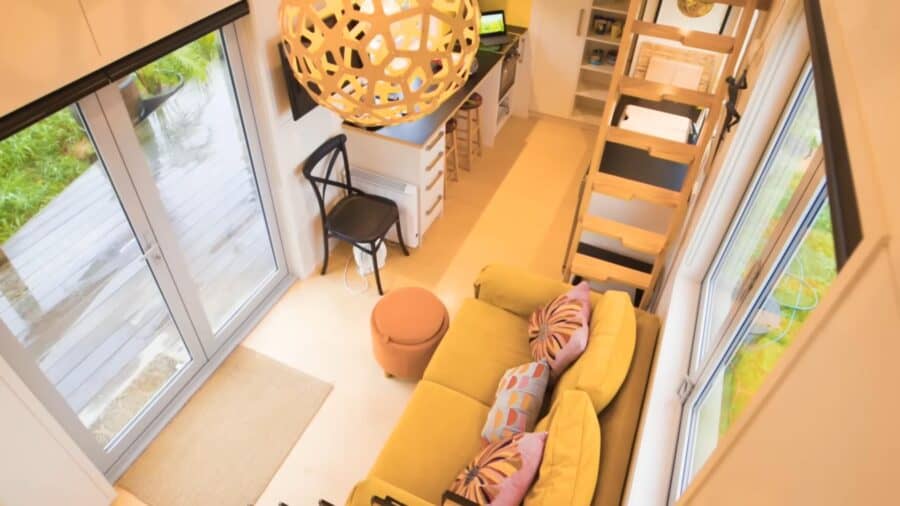 Bright tiny house interior with cozy seating and large windows for natural light.