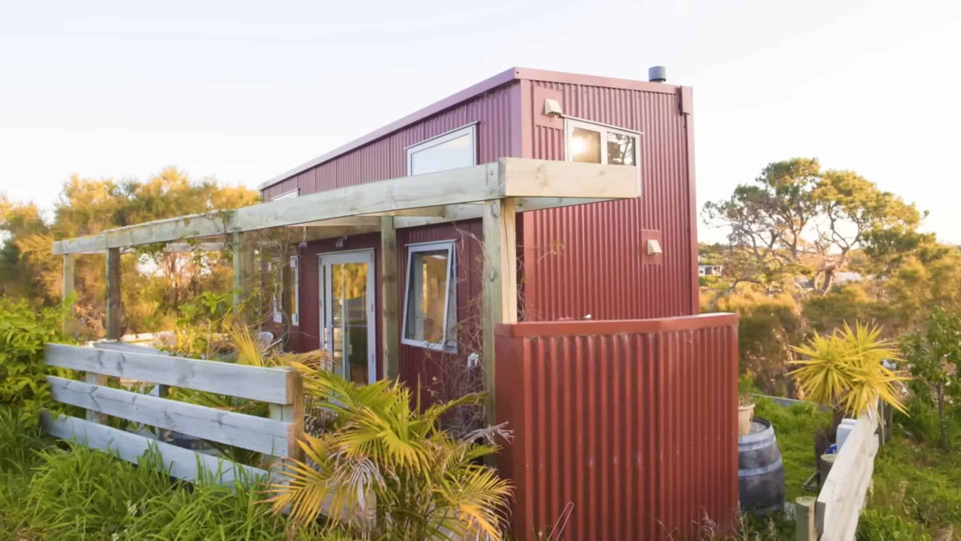 Modern tiny house rental with sleek exterior and outdoor deck in a natural setting.