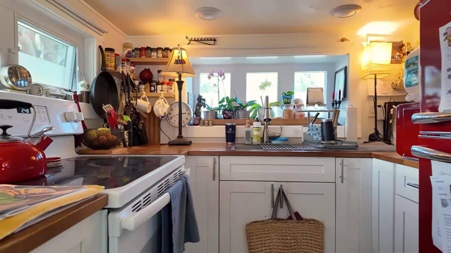 Cozy tiny home kitchen with books and natural light, showcasing small space living.