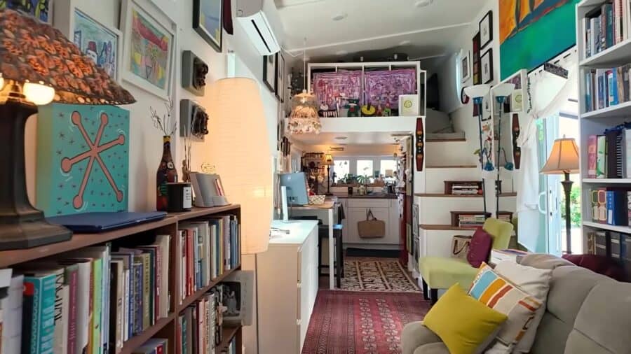 Small tiny house interior with a large collection of books and colorful decor.