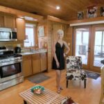 Compact tiny house kitchen with modern appliances and a cozy main floor bedroom in Florida.