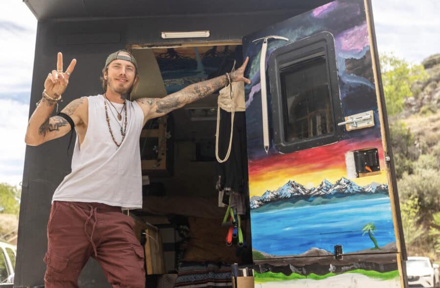 Compact truck camper tiny home with vibrant mountain and lake mural.