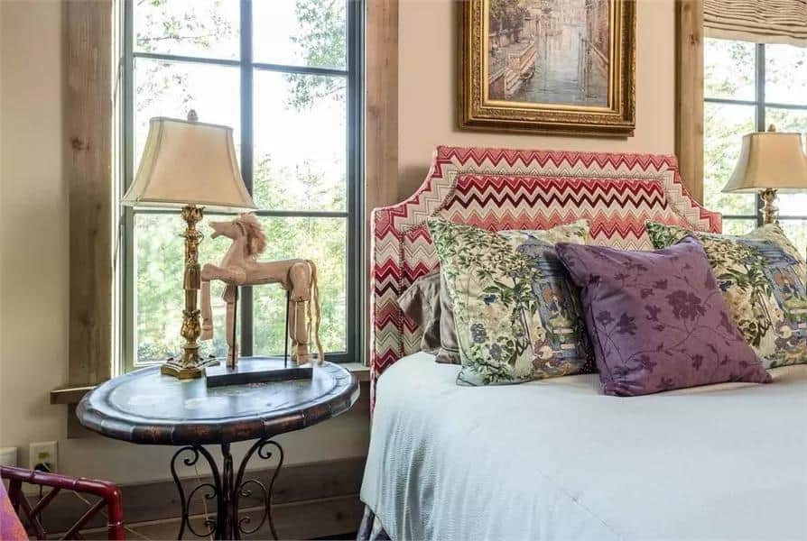 Charming bedroom with vintage decor, floral pillows, and rustic wooden accents.