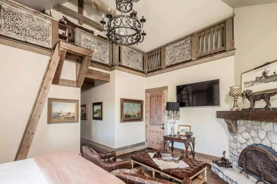 Cozy tiny house living room with rustic decor and stone fireplace.