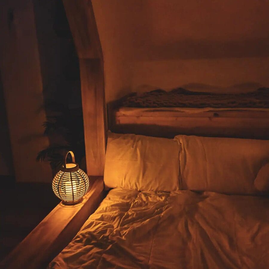 Cozy interior of a honey-inspired tiny house featuring a comfortable bed, warm lighting, and natural.