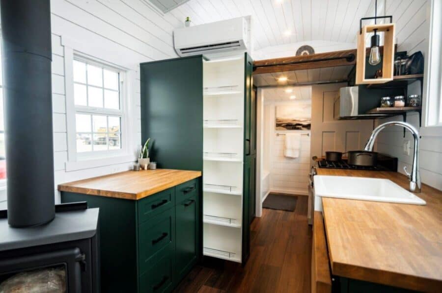 Compact modern tiny house interior with kitchen and storage solutions.